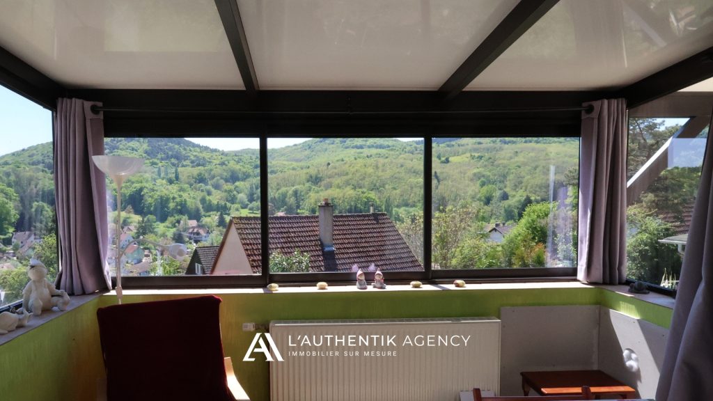 Photographie de la véranda vue depuis la pièce de vie, le salon/séjour. Vue imprenable sur la nature depuis la véranda.