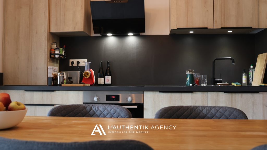 Photographie de la cuisine équipée ouverte sur le salon séjour