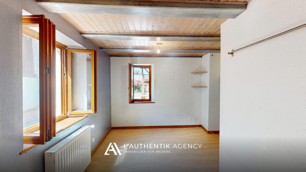 Chambre du rez-de-chaussée avec deux fenêtres donnant sur la cour