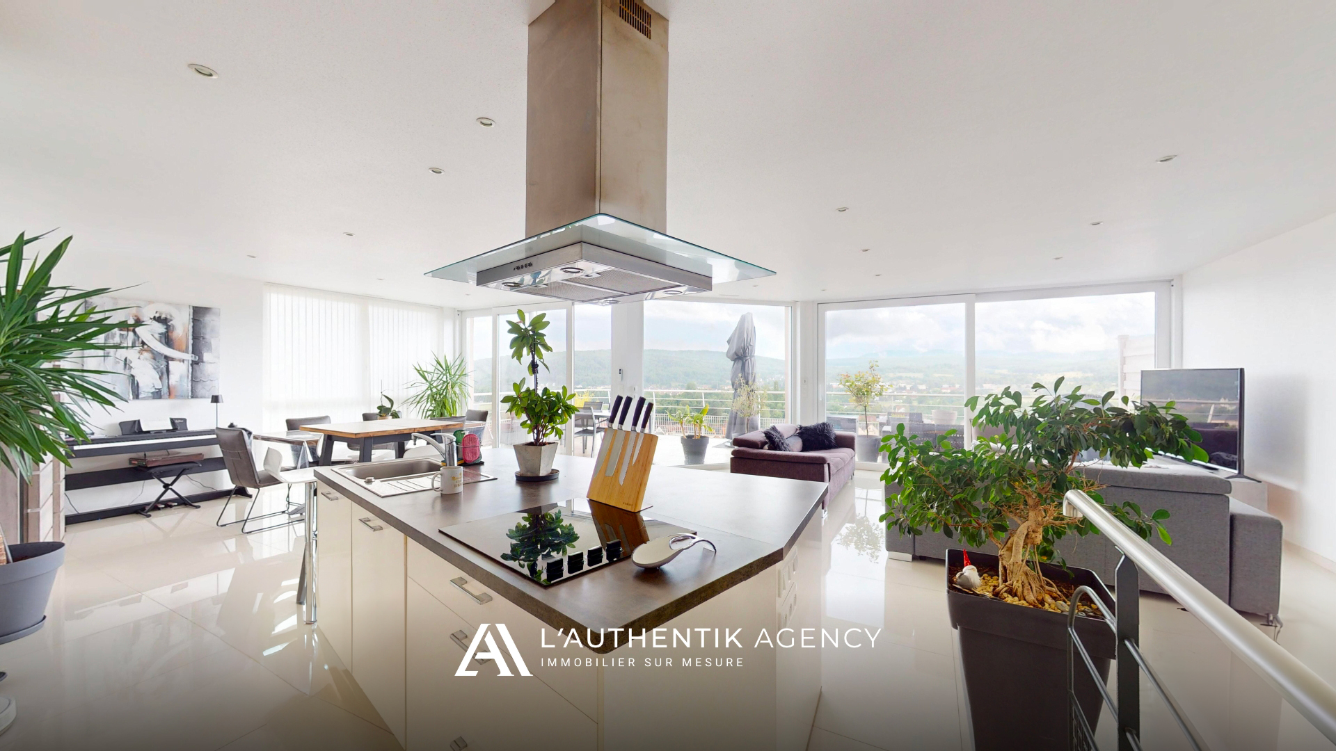photographie de la cuisine équipée aménagée, sa salle à manger et le séjour. Espace bénéficiant d'une vue dégagée sur les collines.