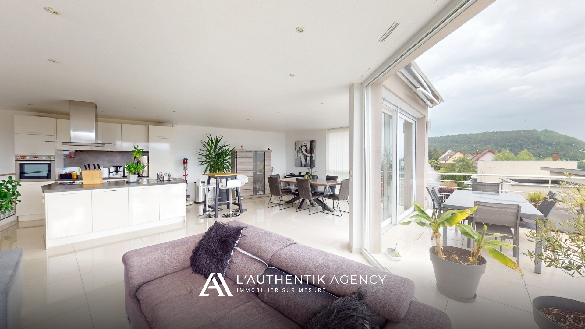 photographie de la pièce de vie avec séjour, cuisine et salle à manger qui donne sur la tarrasse