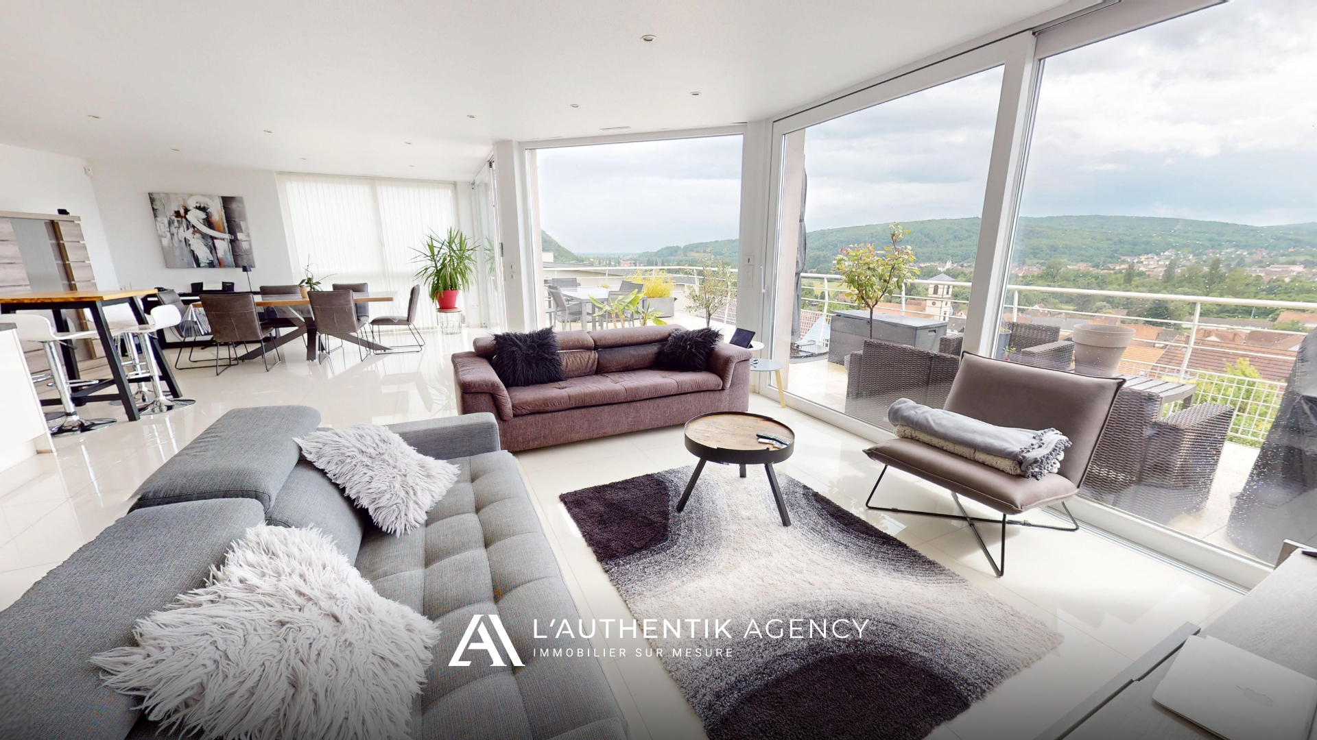 photographie du salon et ses baies vitrées avec vue dégagée sur les collines.
