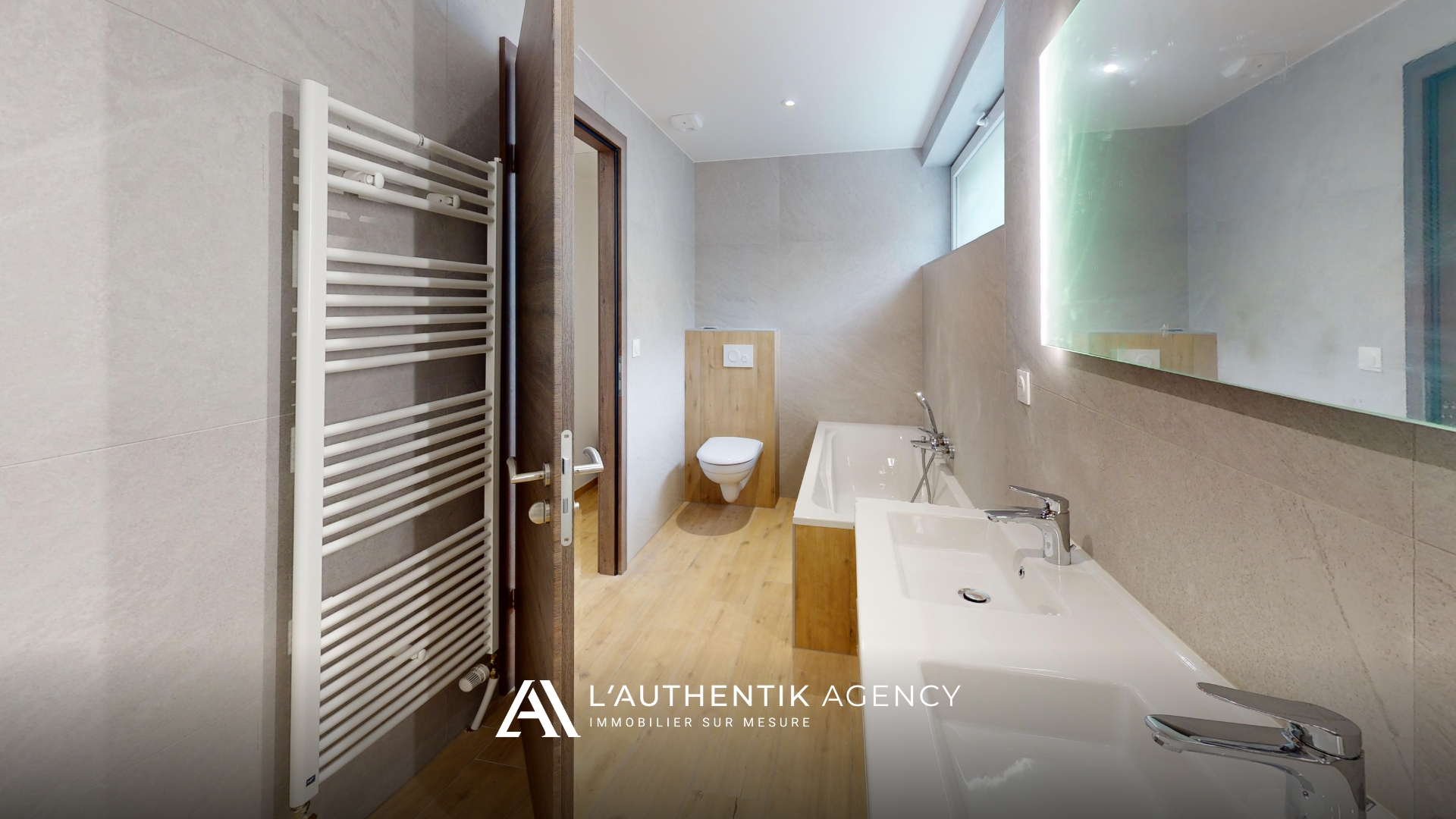 photographie de la salle d'eau avec baignoire, wc et double vasque