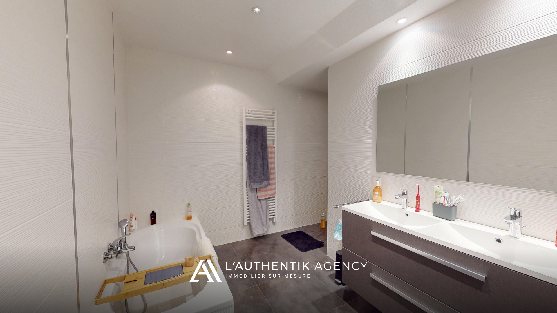 Salle de bain avec baignoire, douche à l'italienne et double vasque.