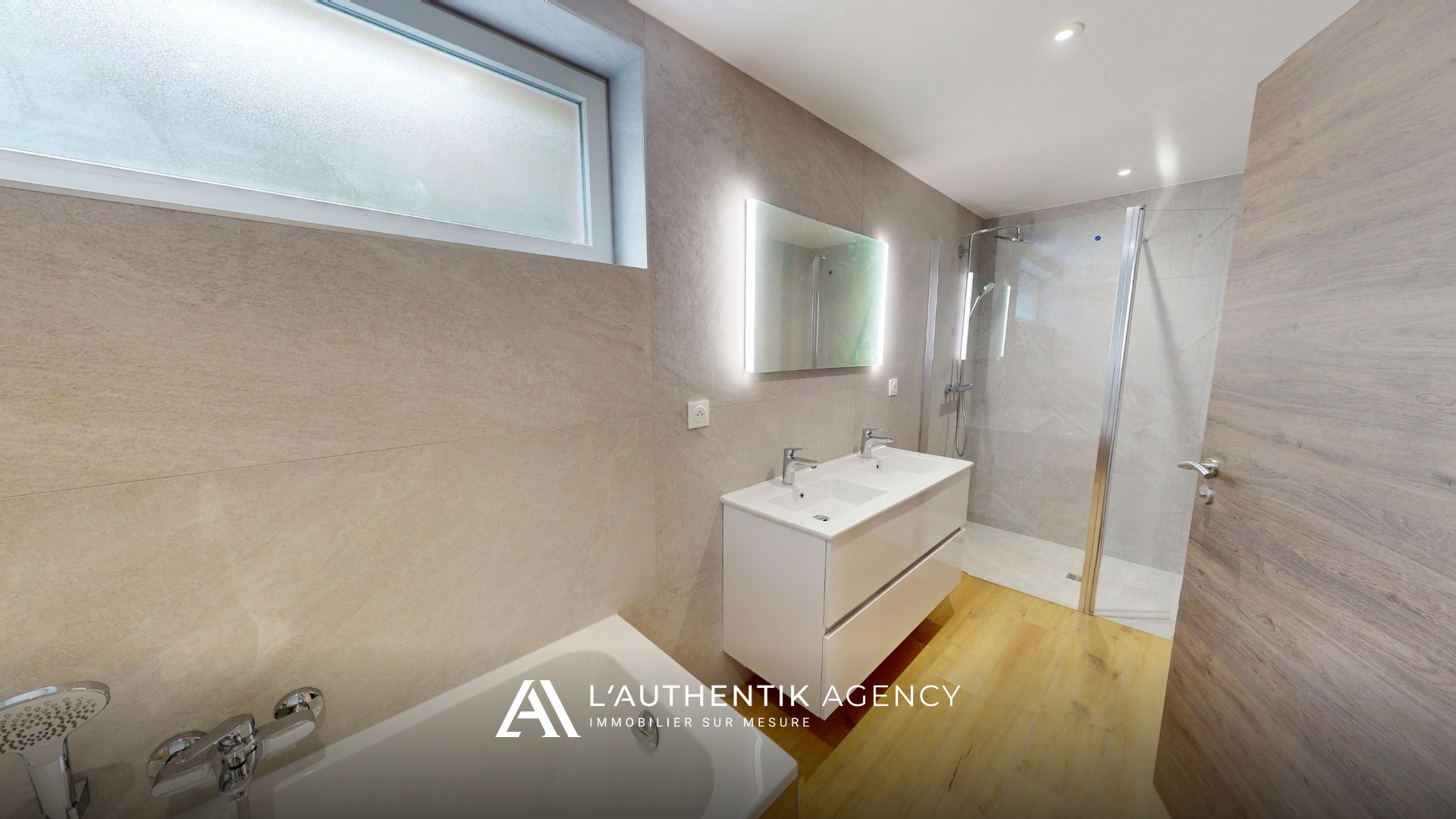 photographie de la salle d'eau avec baignoire, double vasque et douche à l'italienne