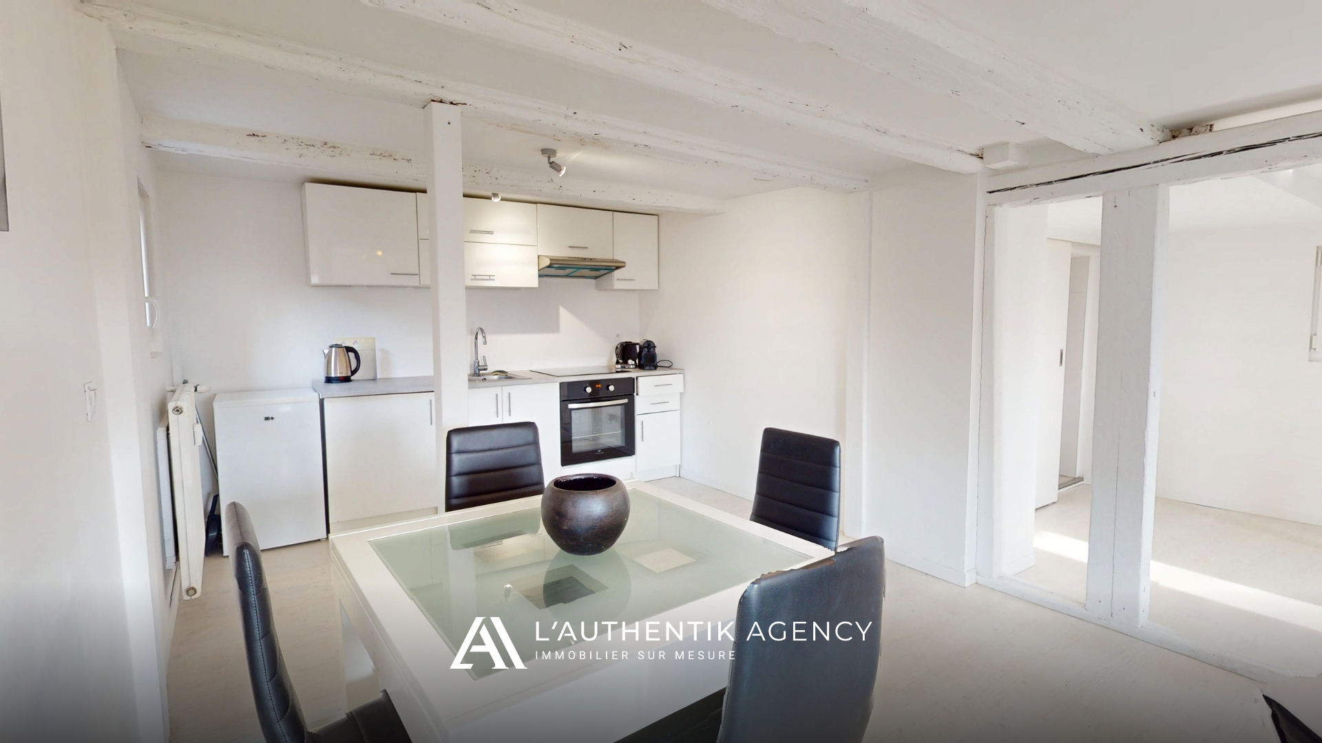 Cuisine équipée moderne ouverte sur la salle à manger et le séjour baigné d'une lumière naturelle au centre-ville d'Obernai