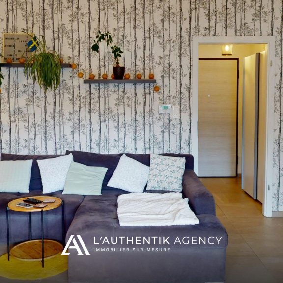 Photographie du salon séjour et de l'entrée depuis la terrasse